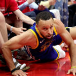 Golden State Warriors star Stephen Curry holding knee during NBA matchup