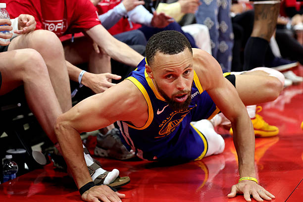 Golden State Warriors star Stephen Curry holding knee during NBA matchup